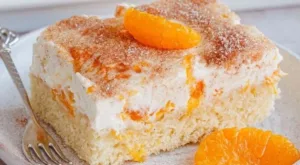 Schmandkuchen vom Blech mit Mandarinen auf einem Teller serviert