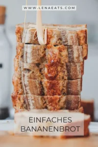 Veganes Bananenbrot mit reifen Bananen und Nüssen auf einem Holzbrett