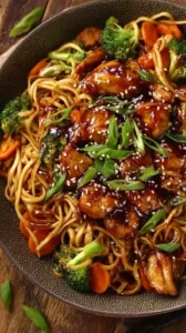 Hähnchen-Teriyaki-Nudeln auf einem Teller serviert mit frischem Gemüse