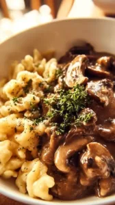 Spaetzle mit cremiger Knoblauch-Pilzsauce auf einem Teller angerichtet