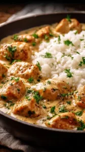 Hähnchenbrust in Sahnesauce mit Reis auf einem Teller serviert