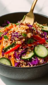 Knuspriger Reis-Salat mit Erdnuss-Sesam-Dressing auf einem Teller