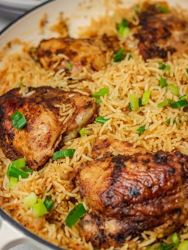 Ein Topf Hühnchen und Reis mit frischen Zutaten und Gewürzen